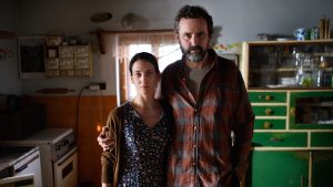 Man and woman standing in dim rustic kitchen